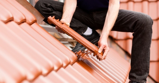 man replacing roof tile